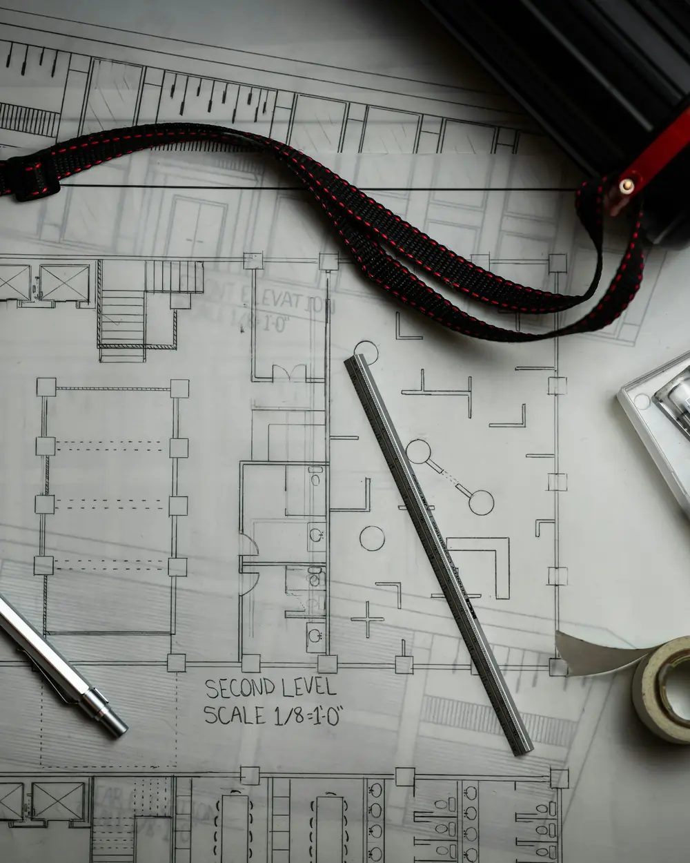 Architectural drawings with drafting pencils, ruler and plan tube