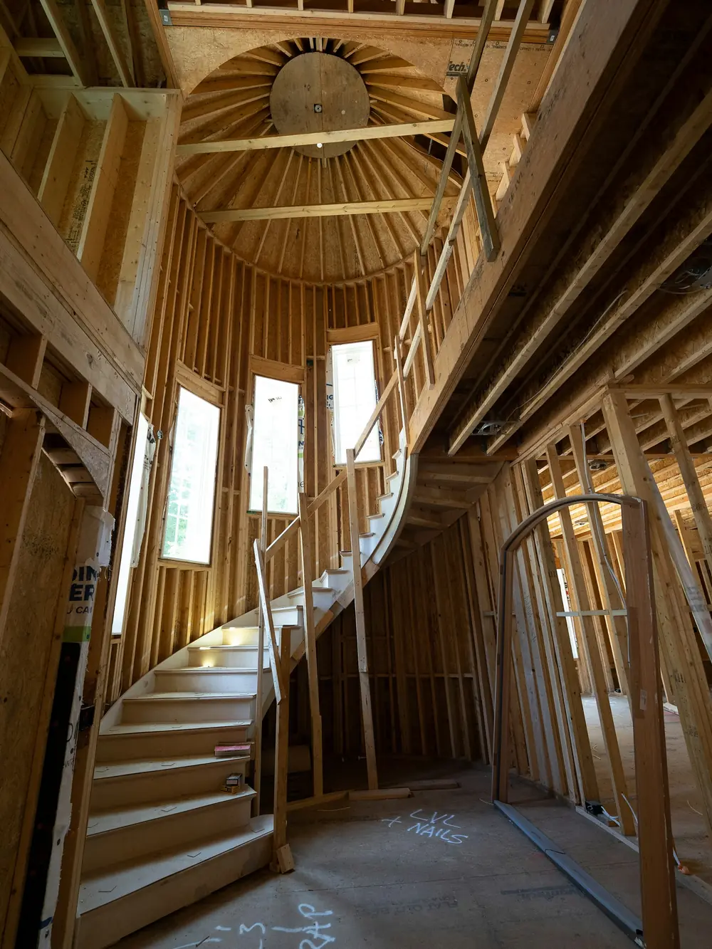 Curved staircase taking shape inside a wood-framed home